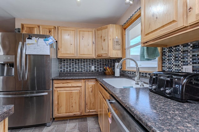 kitchen with light brown cabinets, tasteful backsplash, appliances with stainless steel finishes, and a sink