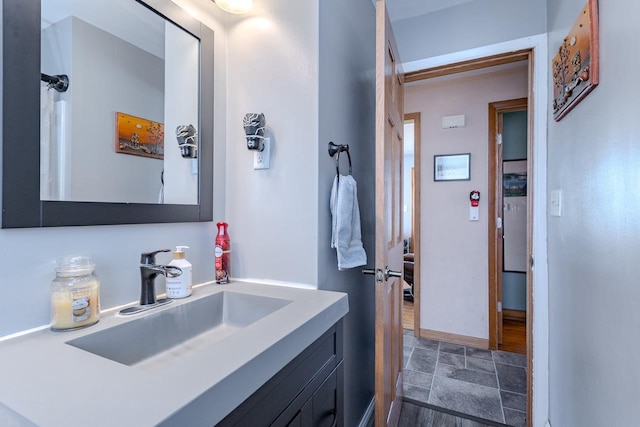 bathroom with baseboards, vanity, and stone finish floor