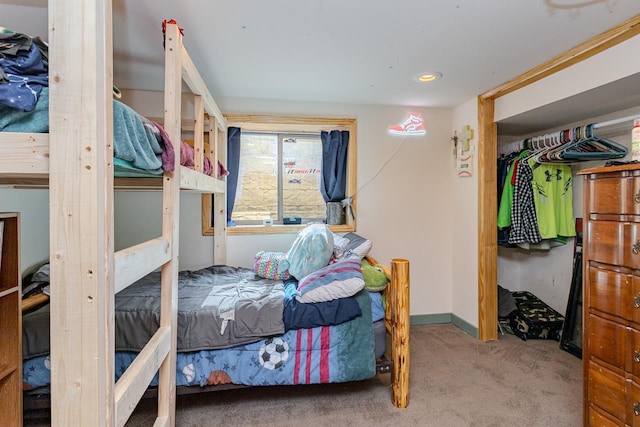 bedroom with carpet, baseboards, and a closet