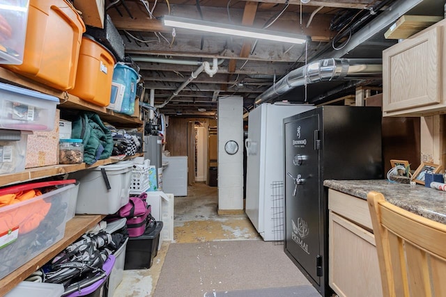 unfinished basement featuring freestanding refrigerator