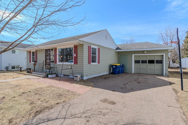 ranch-style house with aphalt driveway, an attached garage, and roof with shingles