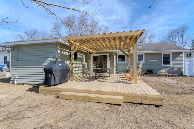 back of property featuring a wooden deck and a pergola