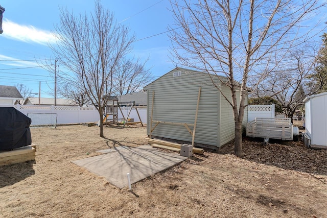 view of yard with an outbuilding, a storage unit, and a fenced backyard