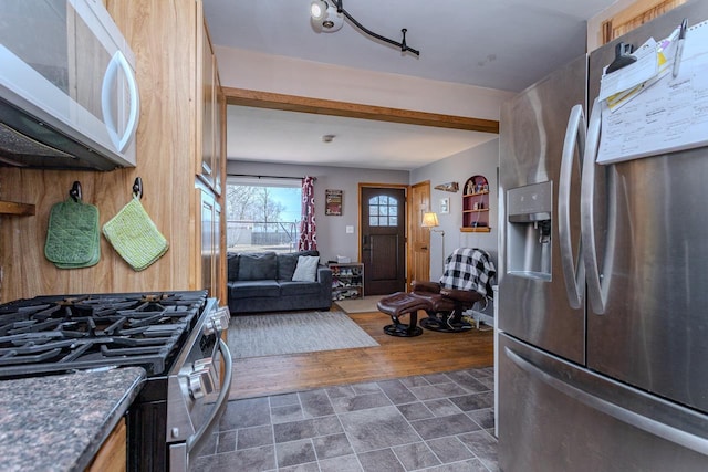 kitchen with dark countertops, appliances with stainless steel finishes, and dark wood-style flooring