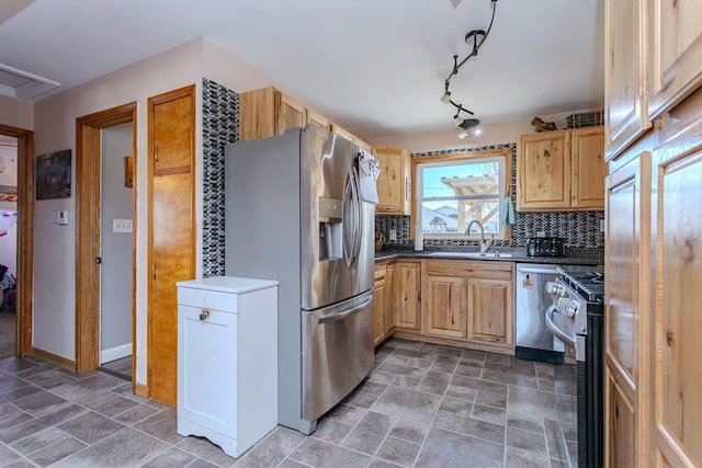 kitchen featuring a sink, stainless steel appliances, tasteful backsplash, and dark countertops