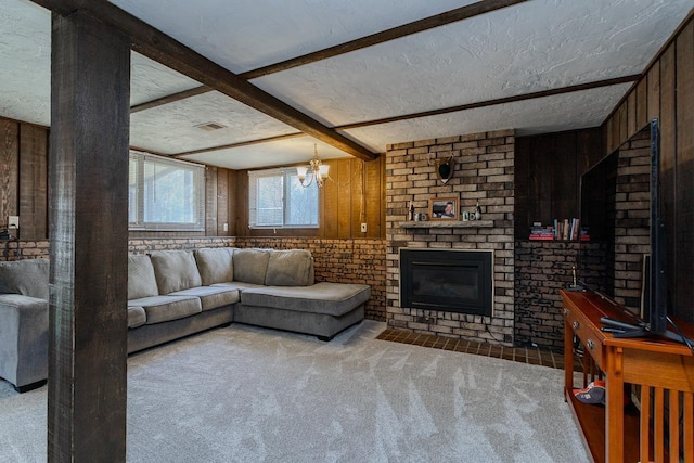 living room with visible vents, a brick fireplace, carpet, beam ceiling, and a textured ceiling