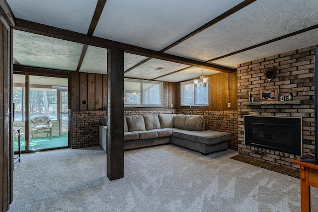 unfurnished living room with beamed ceiling, carpet floors, a textured ceiling, and a fireplace