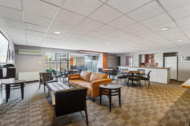 carpeted living room featuring a wall mounted air conditioner, a drop ceiling, and recessed lighting