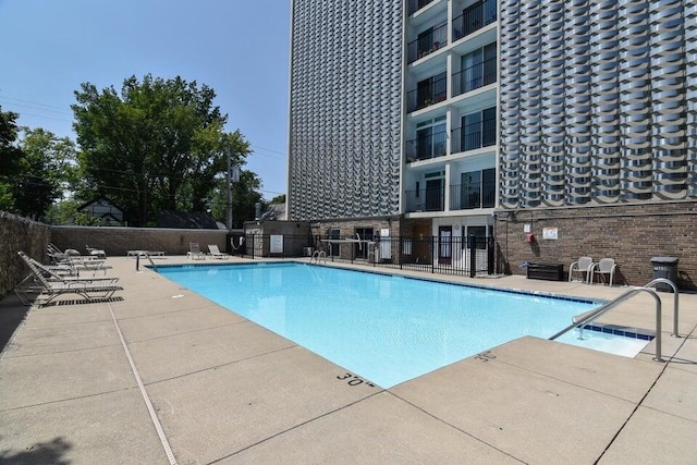 pool with a patio and fence