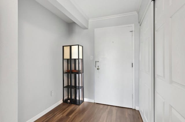 hall featuring dark wood-style floors, crown molding, and baseboards