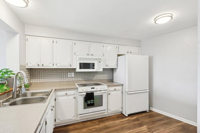 kitchen featuring a sink, backsplash, dark wood finished floors, white appliances, and white cabinets