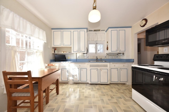 kitchen featuring backsplash, black microwave, decorative light fixtures, electric stove, and a sink