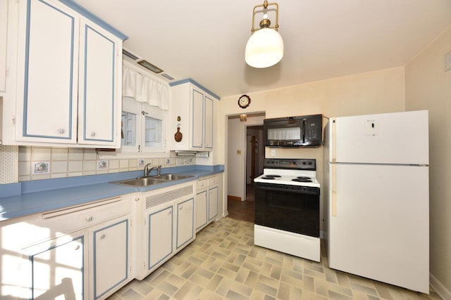 kitchen with freestanding refrigerator, a sink, range with electric cooktop, black microwave, and tasteful backsplash