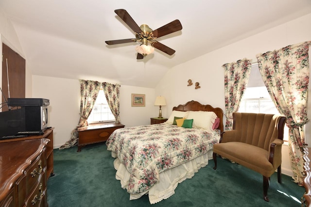 carpeted bedroom with ceiling fan and vaulted ceiling