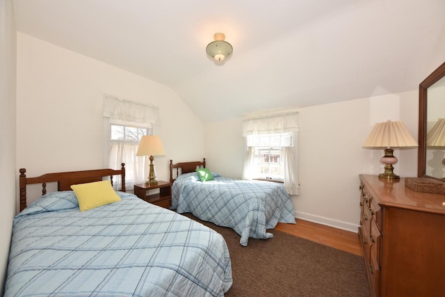 bedroom with lofted ceiling, wood finished floors, and baseboards