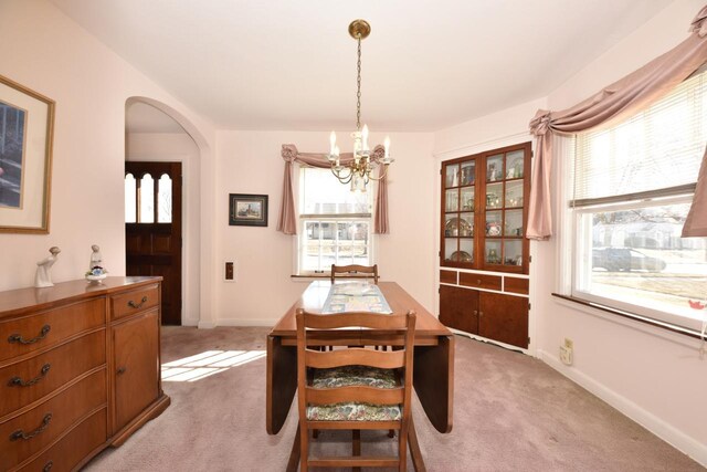 dining room with light colored carpet and a healthy amount of sunlight