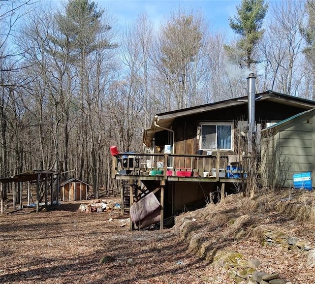 back of house featuring an outbuilding and a deck