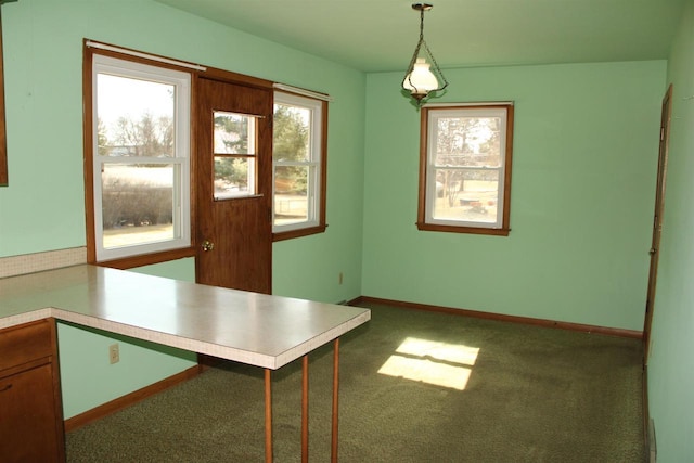 unfurnished dining area featuring baseboards and carpet floors