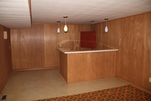 bar with decorative light fixtures, bar area, and wooden walls