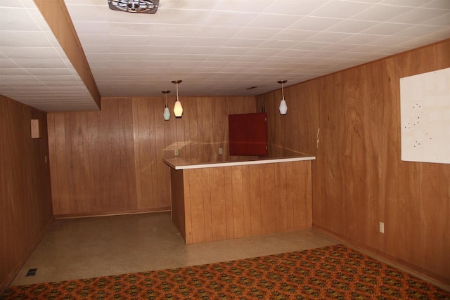 bar with indoor wet bar, wood walls, and decorative light fixtures