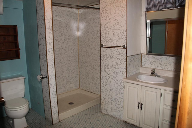 bathroom with toilet, a stall shower, vanity, and tile patterned flooring