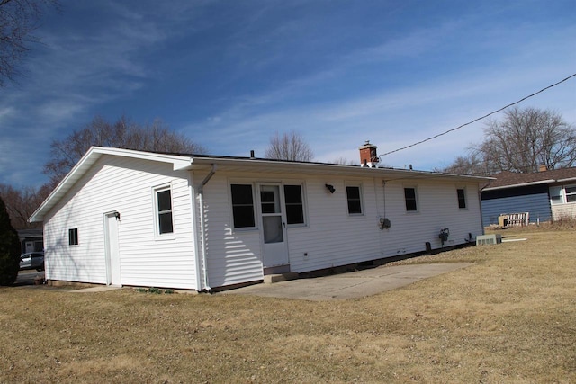 rear view of house with a lawn and central AC