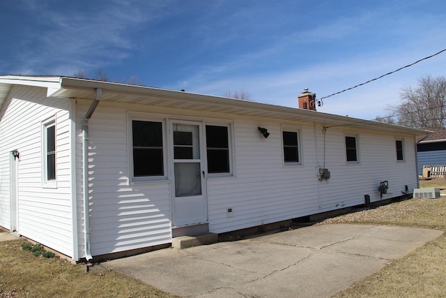 back of house with a chimney