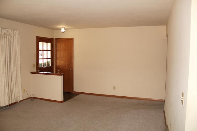 spare room featuring baseboards and carpet flooring