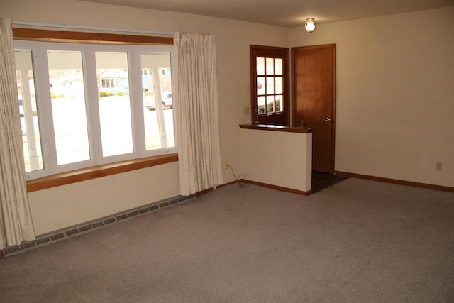 spare room with a baseboard radiator, baseboards, and carpet flooring