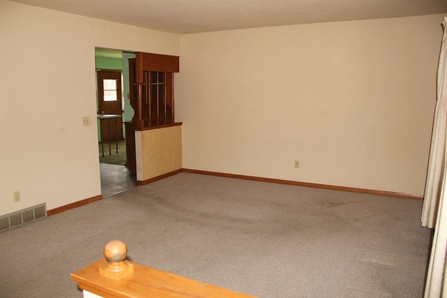 empty room with visible vents, baseboards, and carpet floors