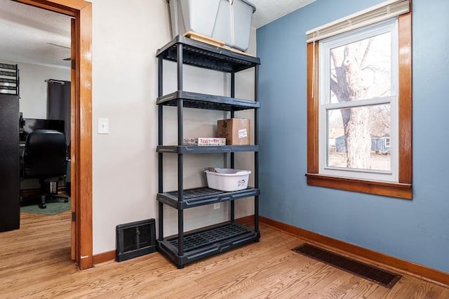 interior space featuring visible vents, baseboards, and wood finished floors