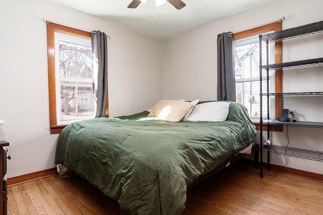 bedroom with wood finished floors, baseboards, and ceiling fan