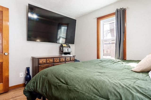 bedroom featuring baseboards and wood finished floors