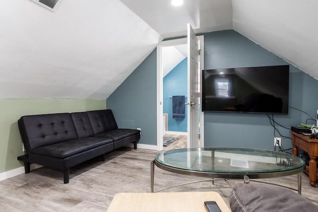 living area with lofted ceiling, wood finished floors, baseboards, and visible vents