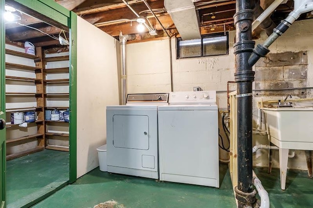 laundry room featuring a sink, concrete block wall, separate washer and dryer, and laundry area