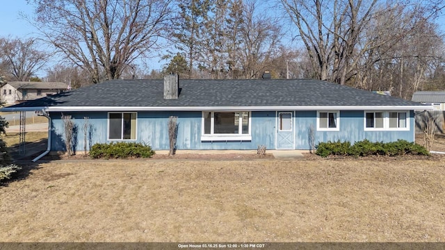 ranch-style home featuring roof with shingles and a front lawn