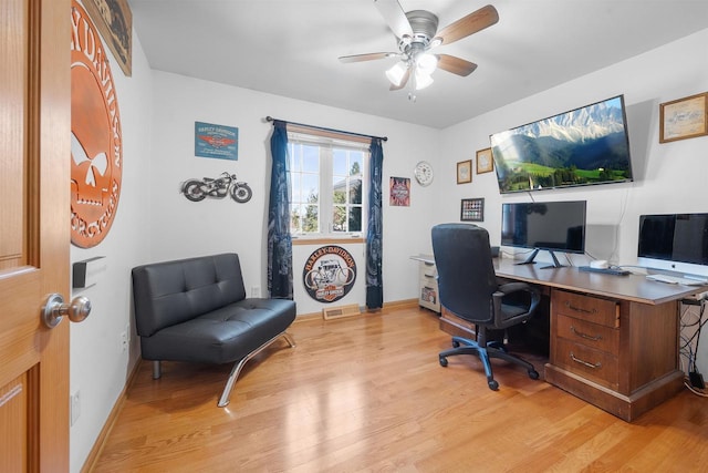 office space with baseboards, light wood-style floors, visible vents, and ceiling fan