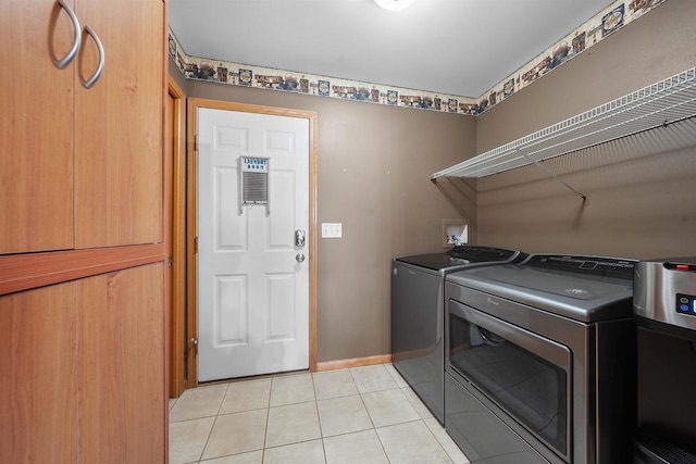 washroom with light tile patterned floors, baseboards, separate washer and dryer, and laundry area