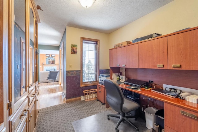 office with wainscoting, a textured ceiling, and light colored carpet