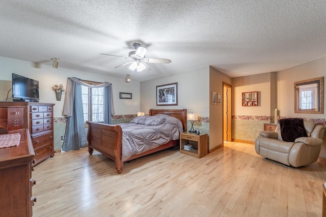 bedroom featuring a textured ceiling, ceiling fan, and light wood finished floors