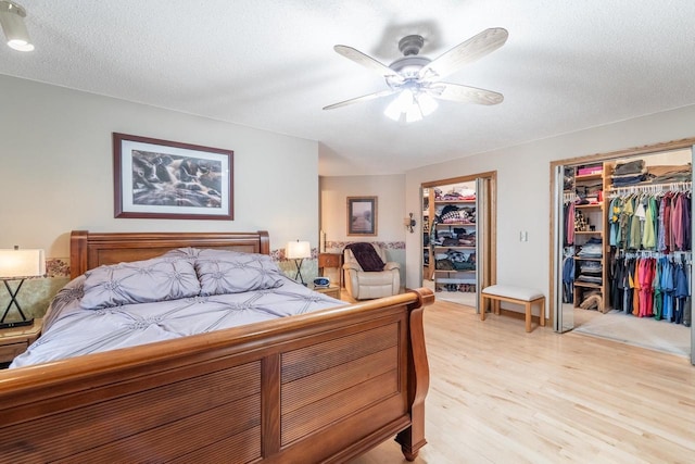 bedroom with a closet, a textured ceiling, ceiling fan, and light wood finished floors