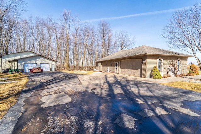 view of property exterior featuring an outbuilding, driveway, and a garage