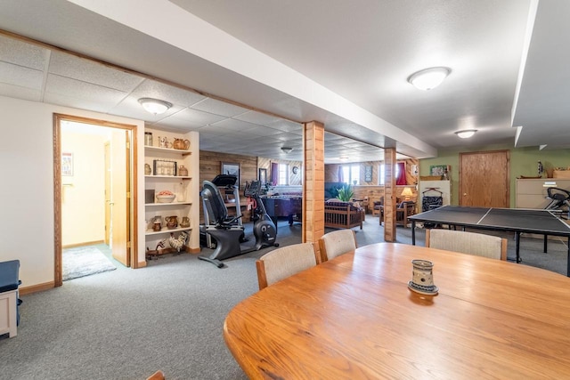 dining space featuring carpet, baseboards, and a drop ceiling