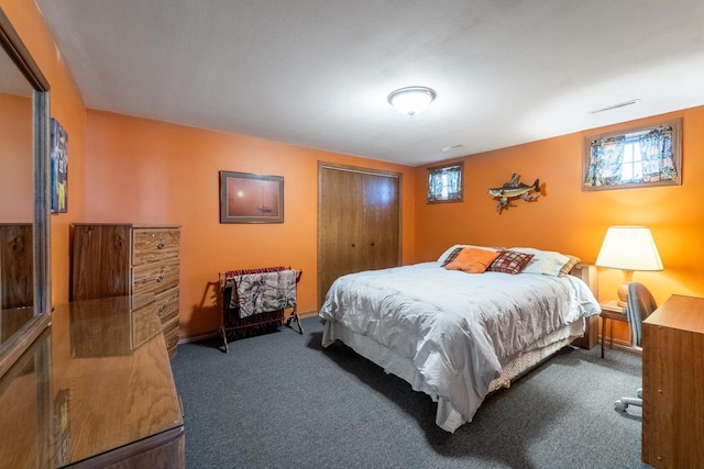 carpeted bedroom featuring visible vents, multiple windows, and a closet