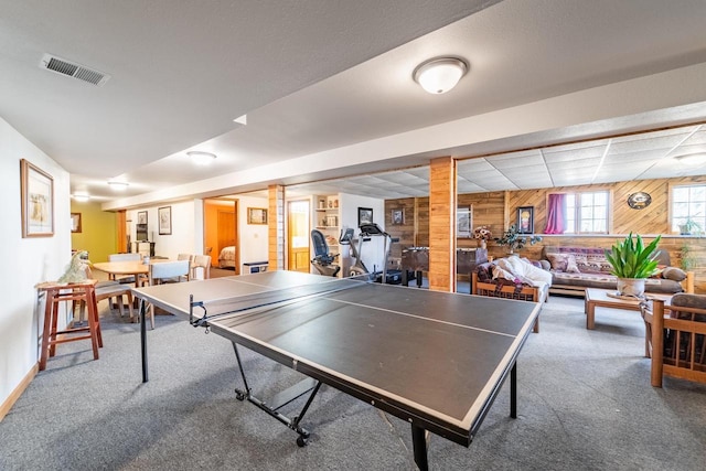 game room with visible vents, baseboards, carpet, and wooden walls