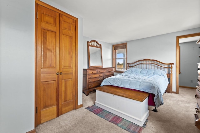 bedroom with baseboards and light carpet