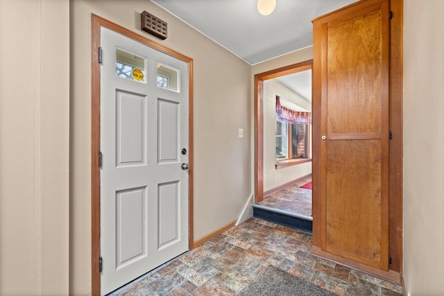 entryway featuring baseboards and stone finish floor