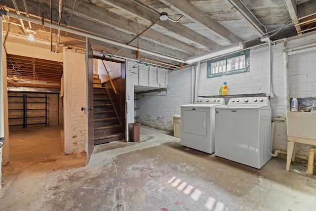 below grade area featuring washer and dryer, stairs, and brick wall