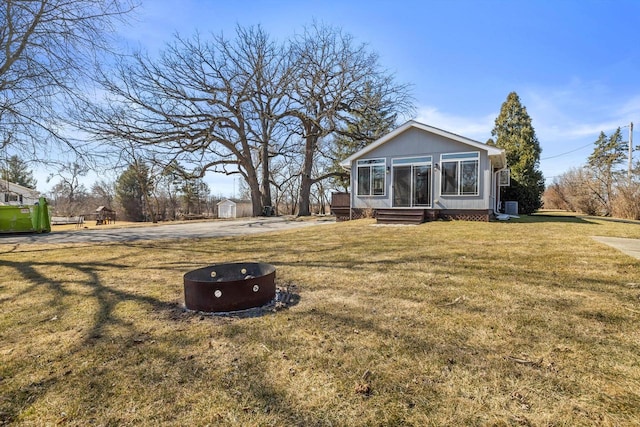 exterior space featuring entry steps, a front yard, and an outbuilding