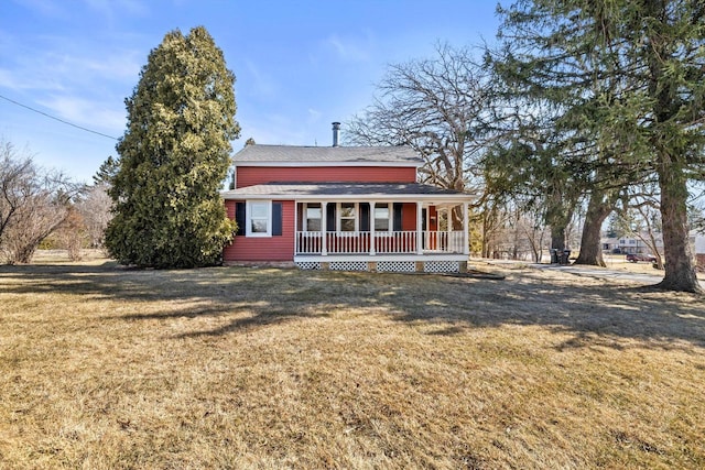 view of front of property with roof with shingles, covered porch, and a front lawn